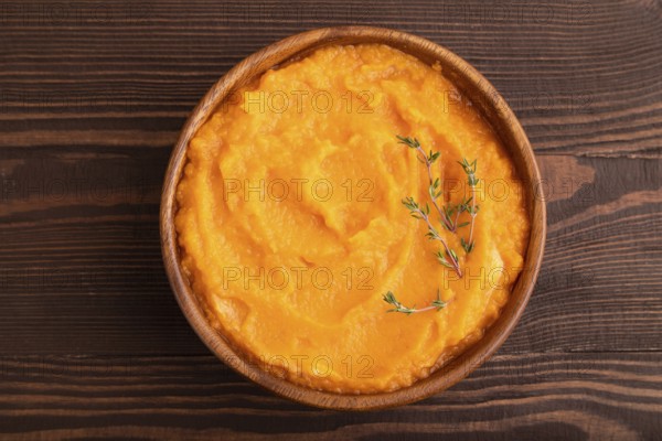 Sweet potato porridge in wooden bowl on wooden background. Diet, healthy eating concept. top view, flat lay, close up, minimalism