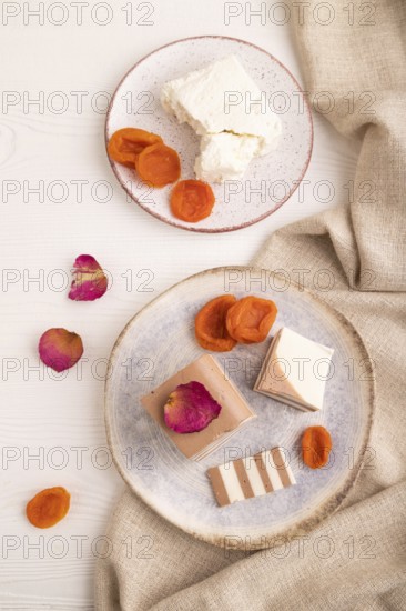 Cocoa and milk jelly with dried apricots on white wooden background and linen textile, top view, flat lay, close up, minimalism