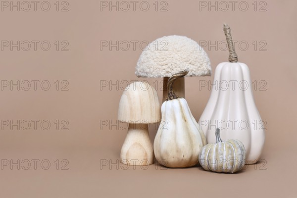 Decorative mushroom and pumpkin ornaments on brown background with copy space. Autumn seasonal composition