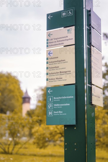 Signpost with various information in a park against an autumnal background, Mainau Island, Lake Constance, Germany