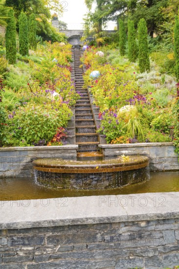 Stepped waterfall in the middle of a flowering garden with colourful plants, Mainau Island, Lake Constance, Germany