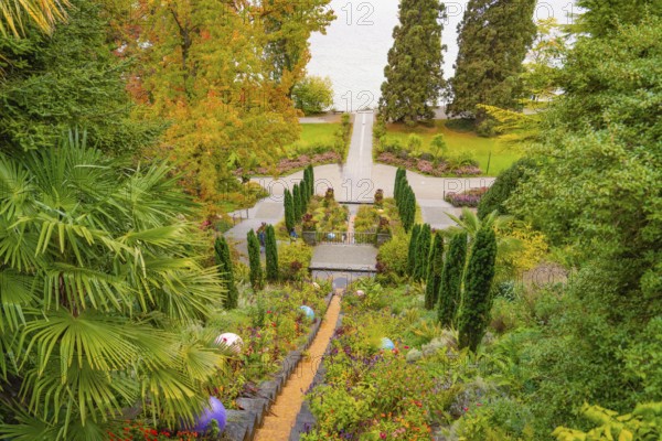 Well-tended garden with steps, lined with flowering plants in autumnal colours, Mainau Island, Lake Constance, Germany