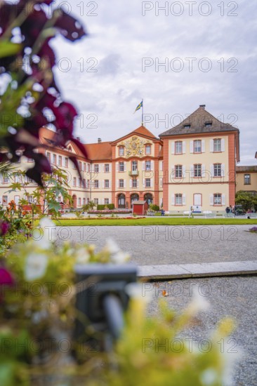 Historic castle building with manicured garden and blooming flowers in the foreground, Mainau Island, Lake Constance, Germany
