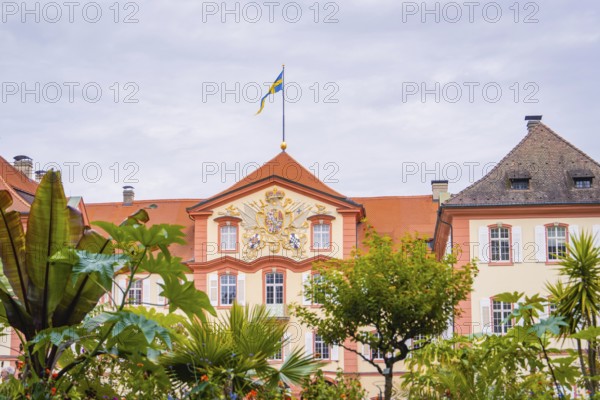Historic building with a flag and plants in the garden, Mainau flower island, Lake Constance, Germany
