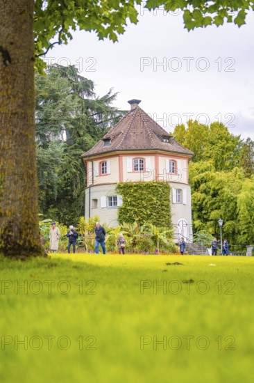 Round shape of the tower in the green park, people in the foreground, Mainau flower island, Lake Constance, Germany