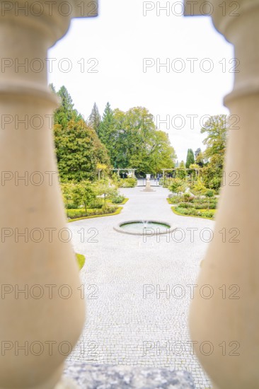 View of manicured path with fountain through decorative columns, Mainau flower island, Lake Constance, Germany