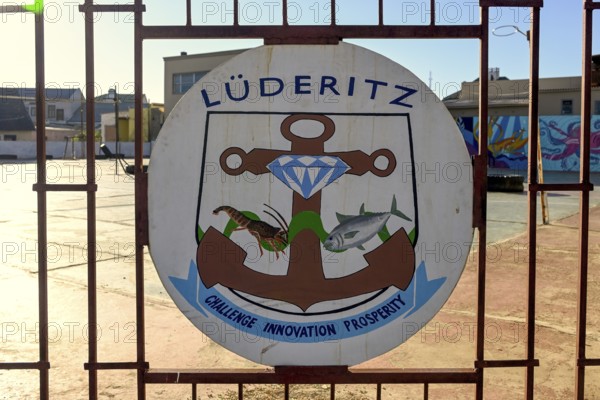 Town coat of arms on a fence, Lüderitz, Karas region, Namibia