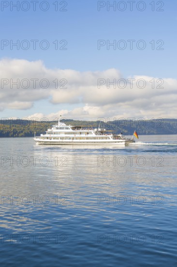 Passenger ship moving on a calm lake under a cloudy sky, Überlingen, Lake Constance, Germany