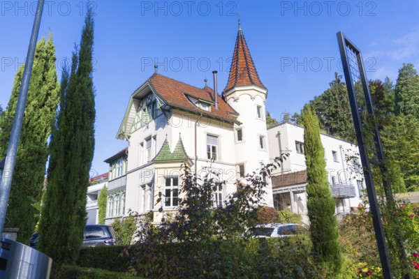 Historic building with tower and pointed roofs, surrounded by trees under a clear sky, Überlingen, Lake Constance, Germany
