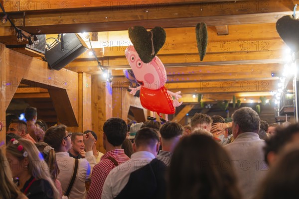 Crowd in a venue with wooden elements and decorations, Cannstatter Wasen folk festival, Stuttgart, Germany