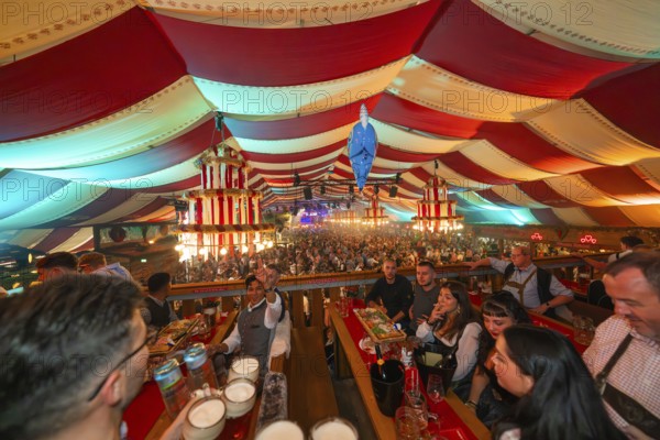 View from above of a colourfully decorated marquee with people celebrating, Cannstatter Wasen folk festival, Stuttgart, Germany