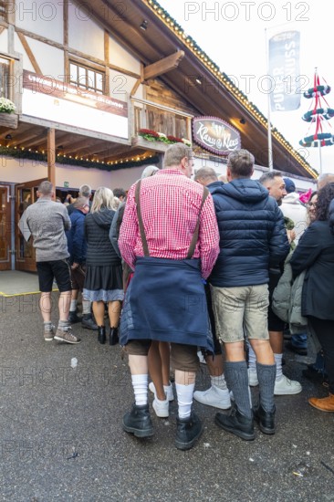 Group of people in traditional Bavarian traditional costume in front of a venue, Cannstatter Wasen folk festival, Stuttgart, Germany