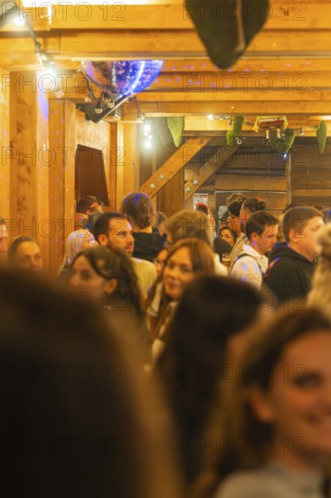 Cramped interior with lots of people, warm light and wooden furnishings, Cannstatter Wasen folk festival, Stuttgart, Germany