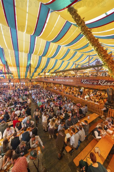 View of a lively festival tent with many people and colourful roof stripes, Cannstatter Wasen folk festival, Stuttgart, Germany