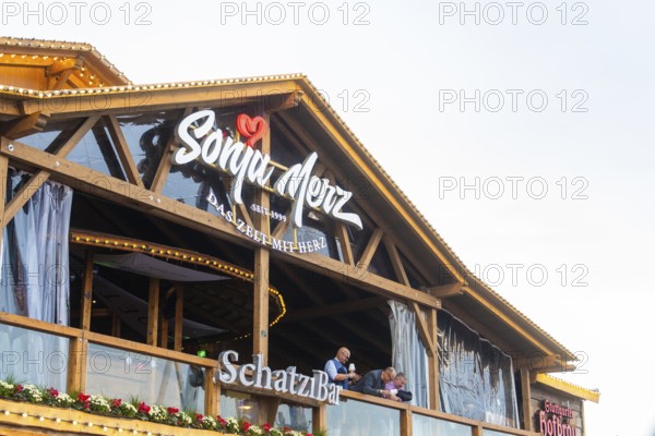 Balcony view of a Bavarian wooden building with festive decoration, Cannstatter Wasen folk festival, Stuttgart, Germany
