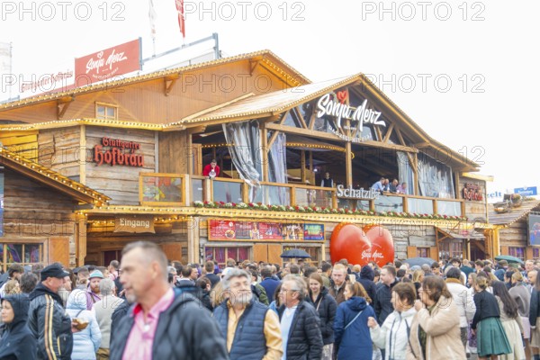 Large crowd in front of a Bavarian festival hall with a warm atmosphere, Cannstatter Wasen folk festival, Stuttgart, Germany