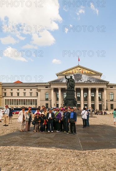 Japanese tourist group in front of the King Max I Joseph Monument. In the back National Theatre Bavarian State Opera, on the left Residenztheater, Munich, Bavaria