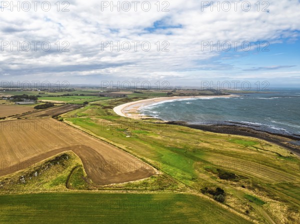 Fields and Farms over Dunstanburgh Castle from a drone, Northumberland Coast, England, United Kingdom