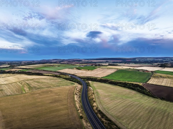 Sunset of Fields and Farms over Traprain Law and Hailes Castle from a drone, River Tyne, Haddington, East Lothian, Scotland, UK
