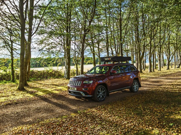 4x4 car with roof tent on autumn forest road, Tyninghame House, River Tyne, East Lothian, Scotland, UK