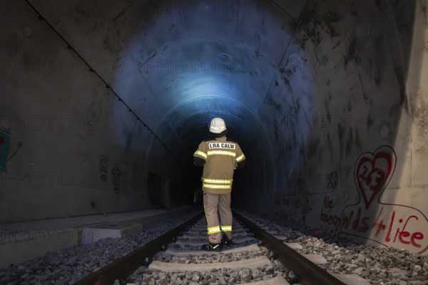 Firefighter in protective clothing enters illuminated tunnel, fire drill in the new tunnel of the Hermann Hesse railway, Ostelsheim, Calw district, Germany