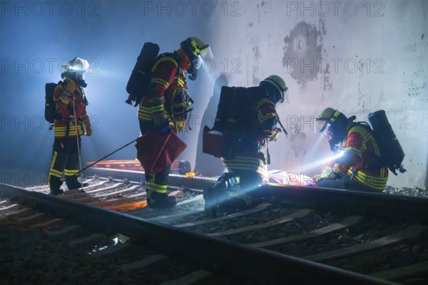 Firefighters during rescue operation on railway tracks at night, firefighting exercise in the new construction tunnel of the Hermann Hessebahn, Ostelsheim, Calw district, Germany