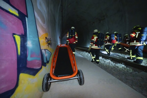 Firefighters pushing a stretcher in a tunnel with graffiti, firefighting exercise in the new construction tunnel of the Hermann Hesse railway, Ostelsheim, district of Calw, Germany