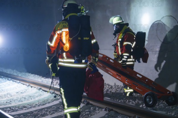 Firefighters carrying a stretcher on tracks in a tunnel, firefighting exercise in the new construction tunnel of the Hermann Hesse railway, Ostelsheim, Calw district, Germany