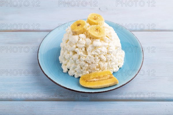 White ?ottage cheese, Curd, with Banana on blue wooden background, side view, close up