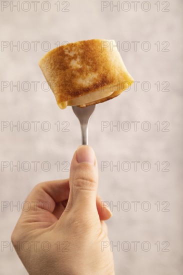 Fried crispy pancakes with meat and cheese with hand. side view, close up, selective focus