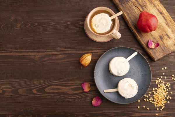 ?hocolate Ice cream in white glaze, cup of coffee, on brown wooden background, top view, flat lay, copy space