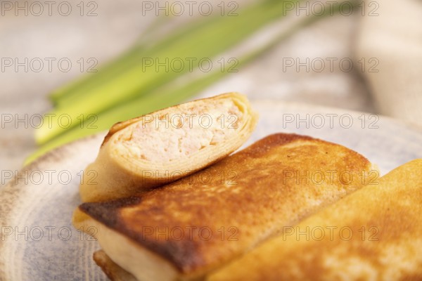 Fried crispy pancakes with meat and cheese on brown concrete background and linen textile. side view, close up, selective focus