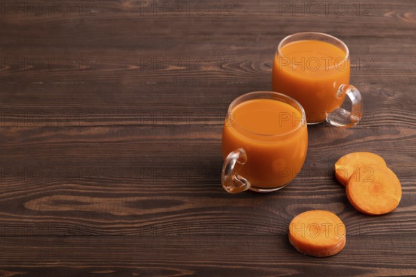Two glasses with carrot juice, on wooden background. Diet, healthy eating concept. side view, copy space, minimalism