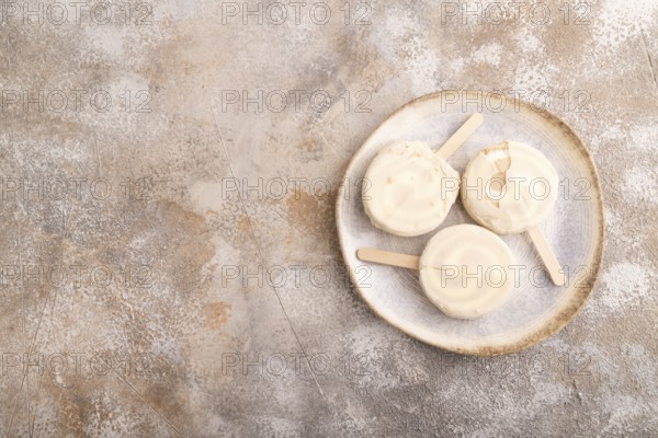 ?hocolate Ice cream in white glaze, on brown concrete background, top view, flat lay, copy space, minimalism