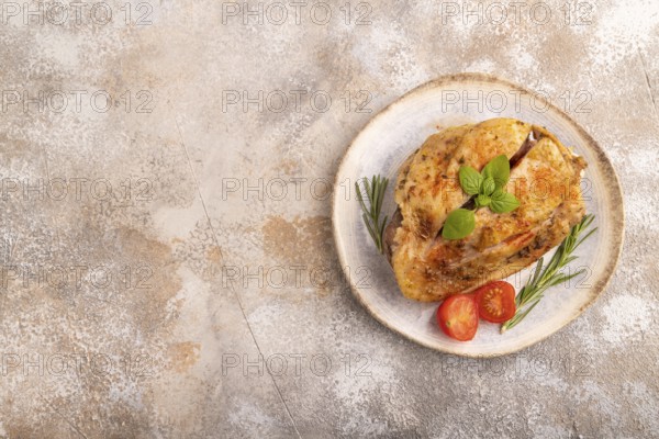 Fried Turkey Thigh with spices and rosemary on plate on brown concrete background. top view, flat lay, copy space