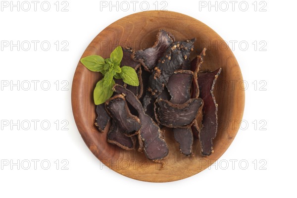 Armenian Basturma dried meat on wooden bowl isolated on white background. Top view, flat lay