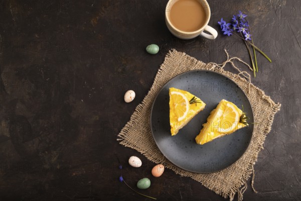Lemon cake on black concrete background and linen textile, cup of coffee, top view, flat lay, copy space