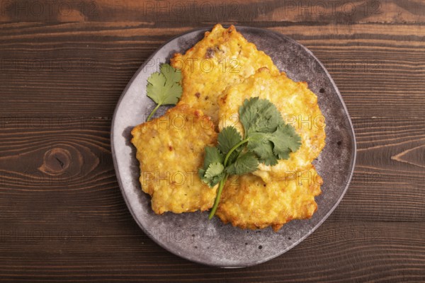 Fried crispy Chicken pancakes on brown wooden background. top view, flat lay, close up