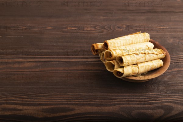 Waffles with caramel on brown wooden background, side view, copy space