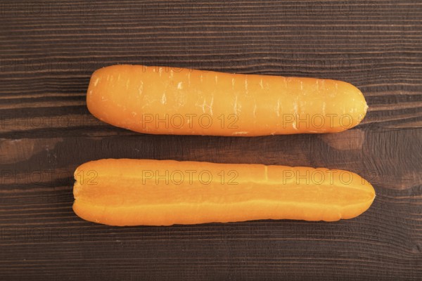Orange Carrot on brown wooden background. Top view, close up, flat lay. healthy food, vegetable, minimalism