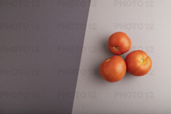 Red tomato on black and gray pastel paper background. Top view, flat lay, copy space. healthy food, vegetable, minimalism