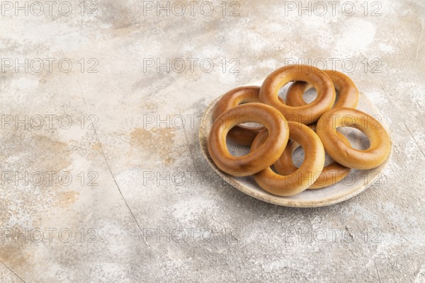 Homemade Ring Bagel on brown concrete background. side view, copy space