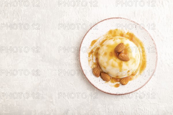 White milk jelly with caramel sauce on gray concrete background. top view, flat lay, copy space