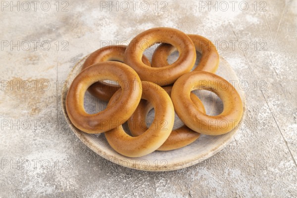 Homemade Ring Bagel on brown concrete background. side view, close up