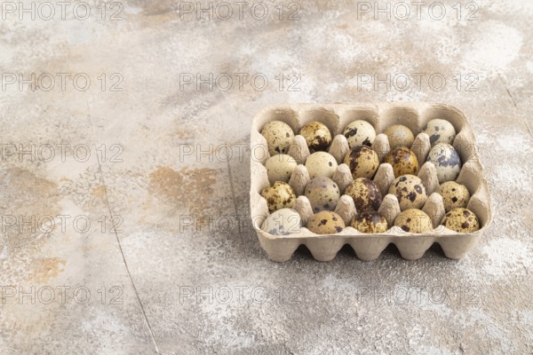 Pile of Raw Quail eggs on a brown concrete background. side view, copy space