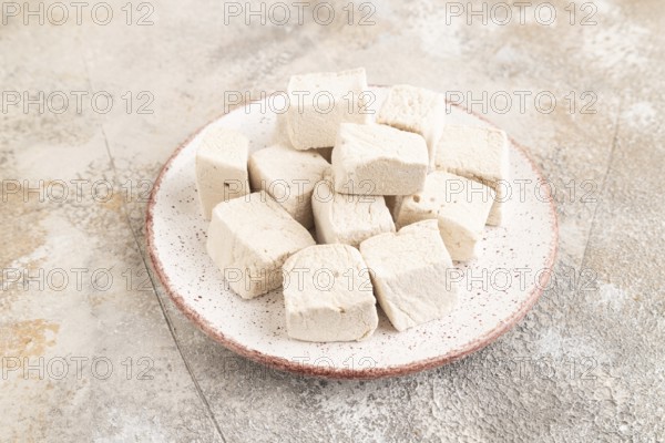 Coffee marshmallow on brown concrete background. side view, close up