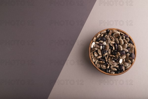 Wooden bowl with Kidney beans on beige and gray pastel paper background, top view, flat lay, copy space, minimalism