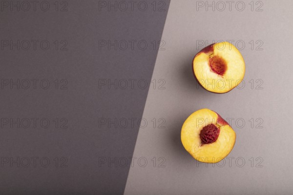 Peach Cut in half on black and gray paper pastel background. Top view, flat lay, copy space. healthy food, minimalism