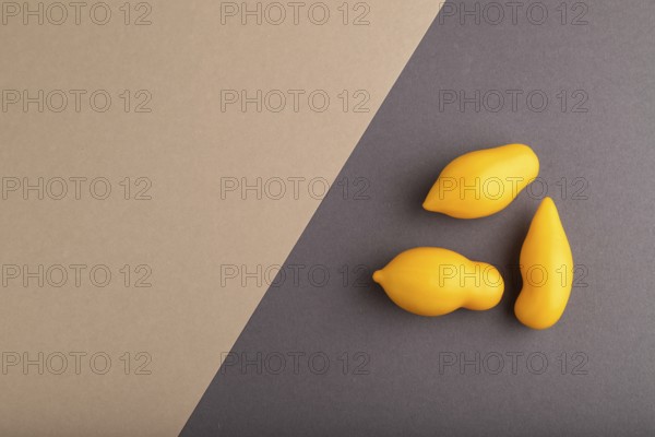 Yellow tomatoes on beige and gray pastel paper background. Top view, copy space, flat lay. healthy food, vegetable, minimalism