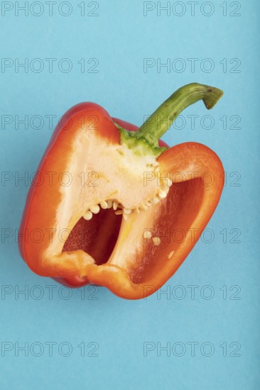 Red Cutted pepper on blue pastel background. Top view, flat lay, copy space. Tropical, healthy food, vegetable, slice, minimalism